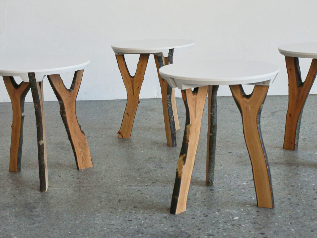 Bild von mehreren Asthockern vor weißer Wand und grauem Steinboden.